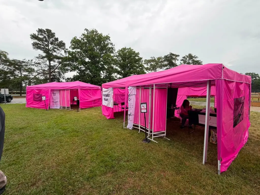 Pink outreach tents set up outdoors for a community event
