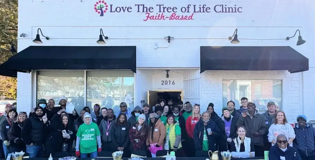 Group of volunteers standing in front of Love The Tree of Life Clinic